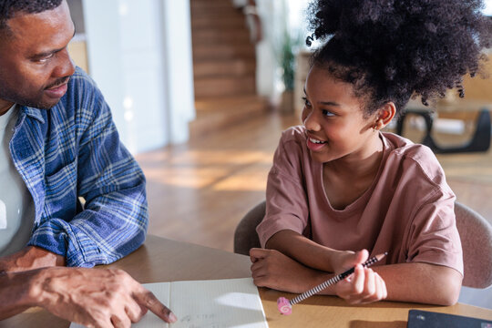 A father helping his daughter with her schoolwork