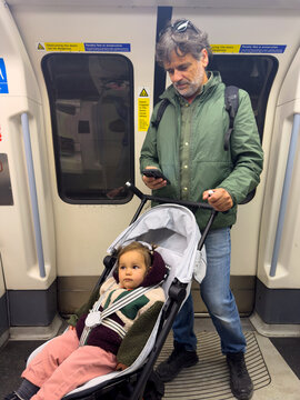 Father Traveling With Baby In London Underground With Stroller