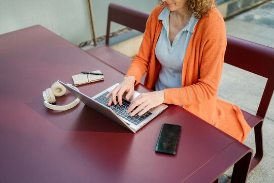 Anonymous Freelance Woman Working on Laptop at Outdoor Table