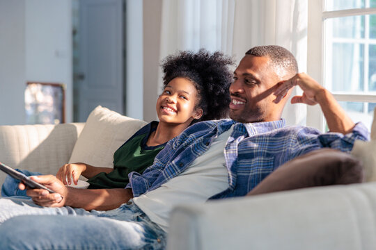 Father and daughter relaxing together on the sofa