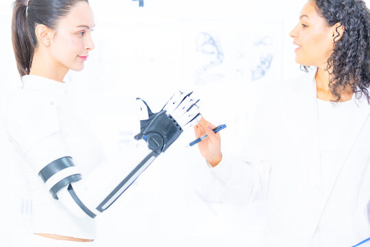 Sensor driven robotics research: the reviewer reaches out with her pen toward the raised robotic fingers, marking where the tactile pads are to be repositioned next