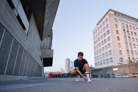 Young man tying shoelace before urban run