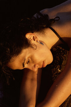 Portrait of a woman lying at the beach during sunset