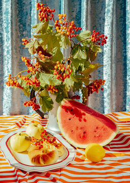 Fruit and flowers displayed on a striped tablecloth