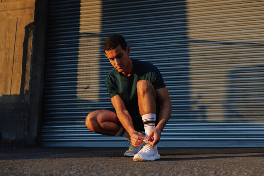 Young man tying shoelace preparing for urban running