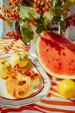 Fruit and baked goods on a table with a striped cloth