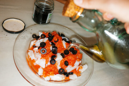 Preparing food. Cod, tomato, and Olive Oil. Direct flash