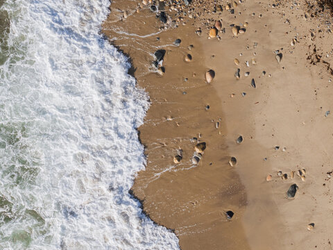 Aerial View of Ocean Waves on Rocky Sandy Beach