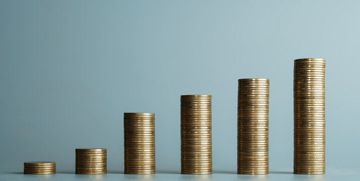 Gold coin stacks arranged in increasing order for financial growth and investment concept