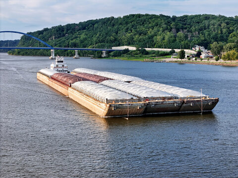 Tugboat navigating South down the Mississippi river pushing a set grain cargo barges