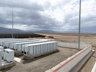 rows of energy storage battery packs in desert landscape © zhu difeng