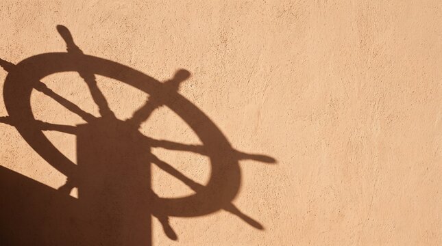 Nautical ship wheel shadow projected on rustic warm plaster wall creating unique minimalist artistic background for coastal and maritime themed design concepts