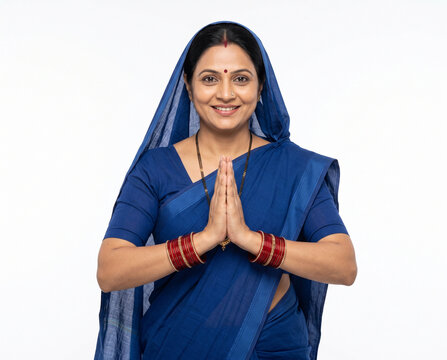 mature indian rural woman in respectful namaste gesture welcoming camera with genuine hospitality for rural social welfare advertising banner ad