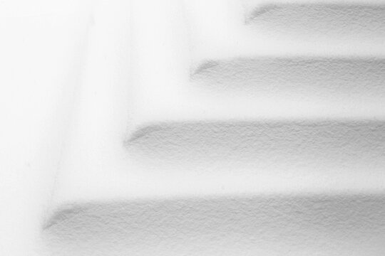 Vue rapproch&eacute;e d'une portion d'escalier couverte de neige blanche. On devine la forme des marches ainsi que les coins gr&acirc;ce aux lignes et aux ombres gris&acirc;tres.   