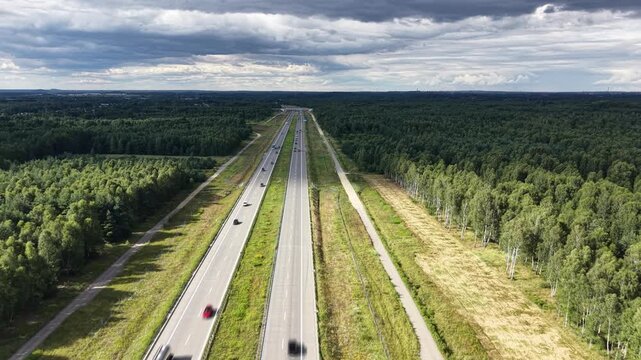 Aerial view of cars moving fast along countryside highway