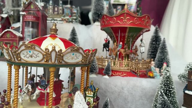 Miniature Christmas village with carousel, festive snowy holiday display