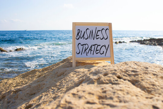 Business Strategy symbol. Blackboard with Concept words Business Strategy. Beautiful sea background. Business and Business Strategy concept. Copy space.