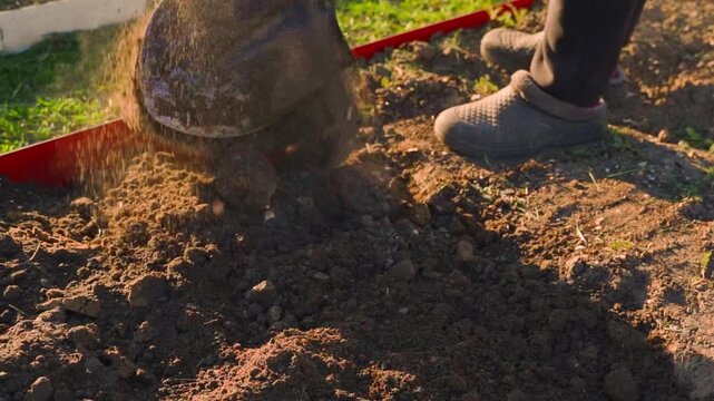 Digging garden soil with shovel in slow motion close-up