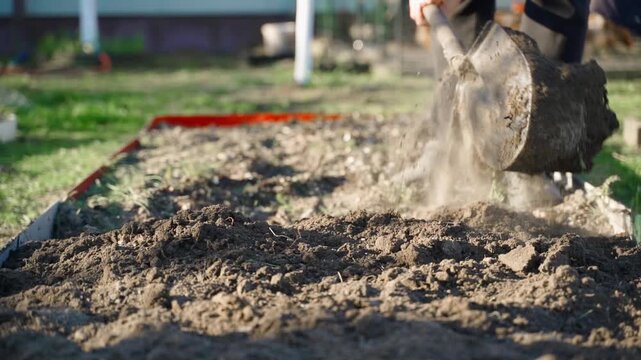 Digging garden soil with shovel in slow motion close-up