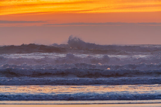 Beautiful wide view of powerful ocean waves crashing at golden sunset