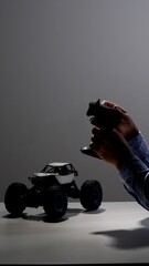Hands holding a modern radio controller operating a white and blue rc monster truck on a table, close up capturing hobby playtime, precision control and joyful interaction © Aliaksandr