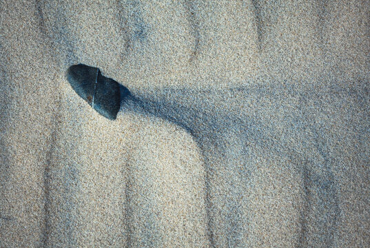 Close-up abstract of perfect wind ripple patterns in white sand dunes forming gentle waves