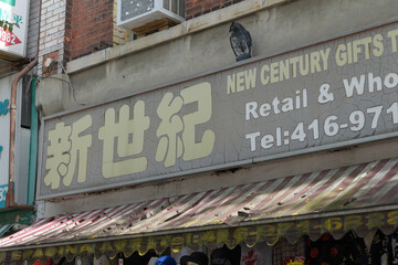 Obraz premium old, vintage sign outside New Century Gifts Trading Co, a gift shop in Chinatown, located at 225 Spadina Av, Toronto