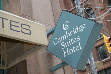 Obraz premium sign outside Cambridge Suites Hotel, a four-star hotel, located at 15 Richmond St E, Toronto