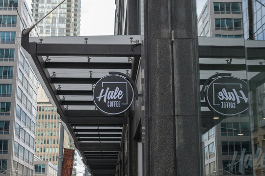 wall-mounted round projecting sign outside Hale Coffee Company located here at 1 Adelaide St E, Toronto