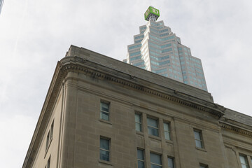 Obraz premium contrast of old building with modern office building: southeast corner of Dominion Public Building (1 Front St W) and TD Place with corporate logo shield at 161 Bay St, Toronto