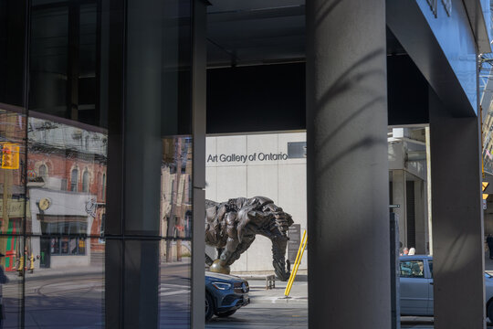 distant, framed view of "Couch Monster: Sadzěʔ yaaghęhch&rsquo;ill" (2022) by Brian Jungen at the corner of Dundas St W and McCaul St, outside the Art Gallery of Ontario (317 Dundas St W), Toronto