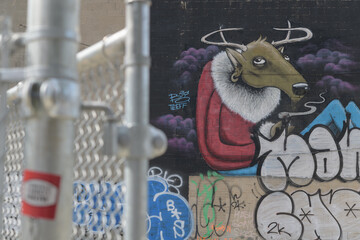 Fototapeta premium defocused view of a barrier fence and detail of street art mural by Greg Mike and Big Teeff located at 464-470 Queen St W, Toronto
