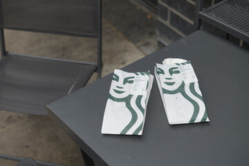 Obraz premium Starbucks bakery bags on a table outside a coffee shop in Toronto (Egg White & Roasted Red Pepper Egg Bites)