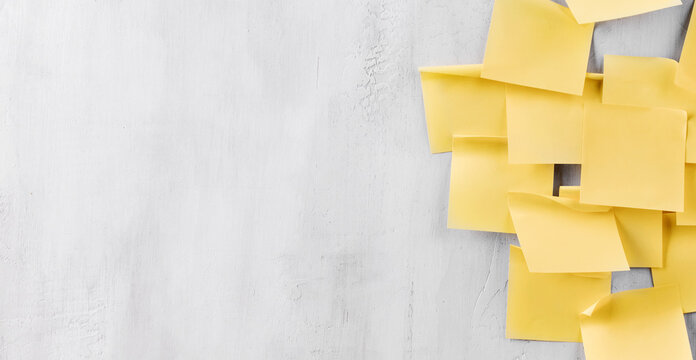 Yellow sticky notes on a gray wall with open copy space on the left