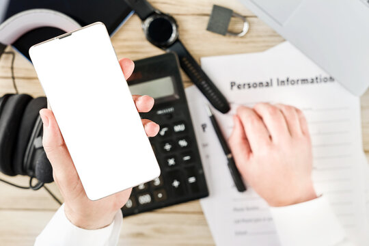 Hand holds a blank smartphone while filling a personal information form for privacy