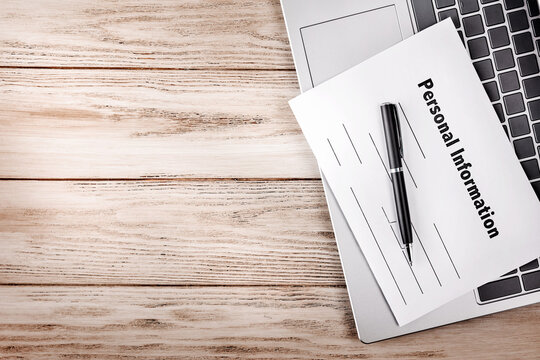 Personal information form on a laptop with wooden copy space for data privacy