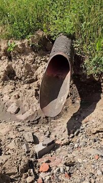 Construction of a drainage pipe in a grassy area during the day