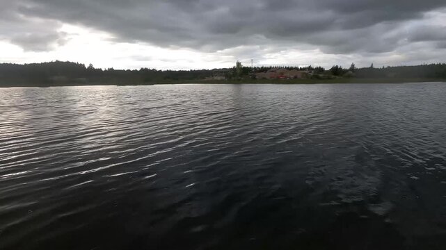 Rippling Lake Water Reflecting Light Beneath Cloudy Sky