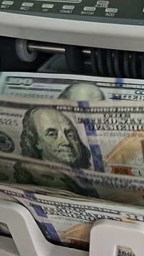 Counting money using a currency counting machine in a bank office