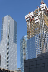 Obraz premium an upward view of the completed Thomson Reuters building (19 Duncan St) and construction of Forma Condos, East Tower, at 266 King St W, Toronto