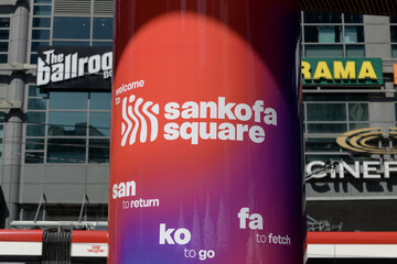 Obraz premium concrete pillar with signage at Sankofa Square (looking north to The Tenor and defocused signage on the outside), Toronto