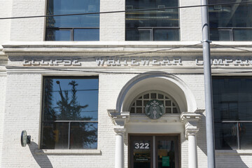 Obraz premium Starbucks Siren logo outside the historic Eclipse Whitewear Company at 322 King St W (at John), Toronto