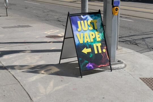 sidewalk a-frame poster sign outside Just Vape It located at 103 Mutual St (seen here on Dundas St E), Toronto