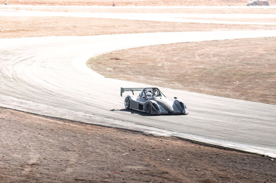 Racecar speeding around a curve on a track,