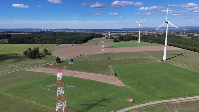 vue a&eacute;rienne panoramique des &eacute;oliennes et des pyl&ocirc;nes &agrave; haute tension &eacute;lectrique qui produisent et  transportent l'&eacute;nergie dans la r&eacute;gion de Bastogne, en Belgique, pr&egrave;s du village de Sibret. 