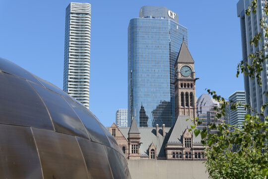 contrast of the Teaching Lodge at the Spirit Garden contrast with Massey Tower condos, Cadillac Fairview business tower, and clock tower of Old City Hall, Toronto