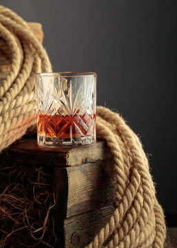Glass of whiskey on a rough wooden crate.