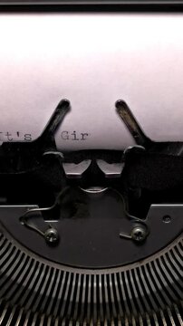 Vertical Macro Shot of Vintage Typewriter Typing the Words It's a Girl