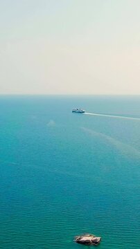 Vertical video. Kavala, Greece. Kavala Fortress. The ferry leaves the port. Historic city center. Aegean Sea. Summer. Drone footage, Departure of the camera. Rich colors