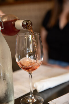 rose getting poured into a glass at a restaurant table, selective focus